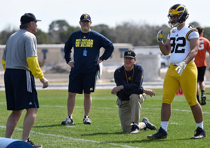 Michigan's head coach Jim Harbaugh, center right, watches defensive coordinator Don Brown, left, work with Cheyenn Robertson during team practice in Bradenton, Fla., Monday, Feb. 29, 2016. (Tiffany Tompkins/The Bradenton Herald via AP) MANDATORY CREDIT
            