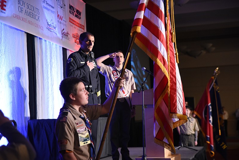 Nathan Goza, right, leads a large crowd of former scouts and attendees in the Boy Scout Oath at the outset of the 12th Annual Friends of Scouting Luncheon at the Chattanooga Convention Center on Wednesday. Chattanooga Police Chief Fred Fletcher stands with him as color guard member Joel Hunt holds the American Flag.