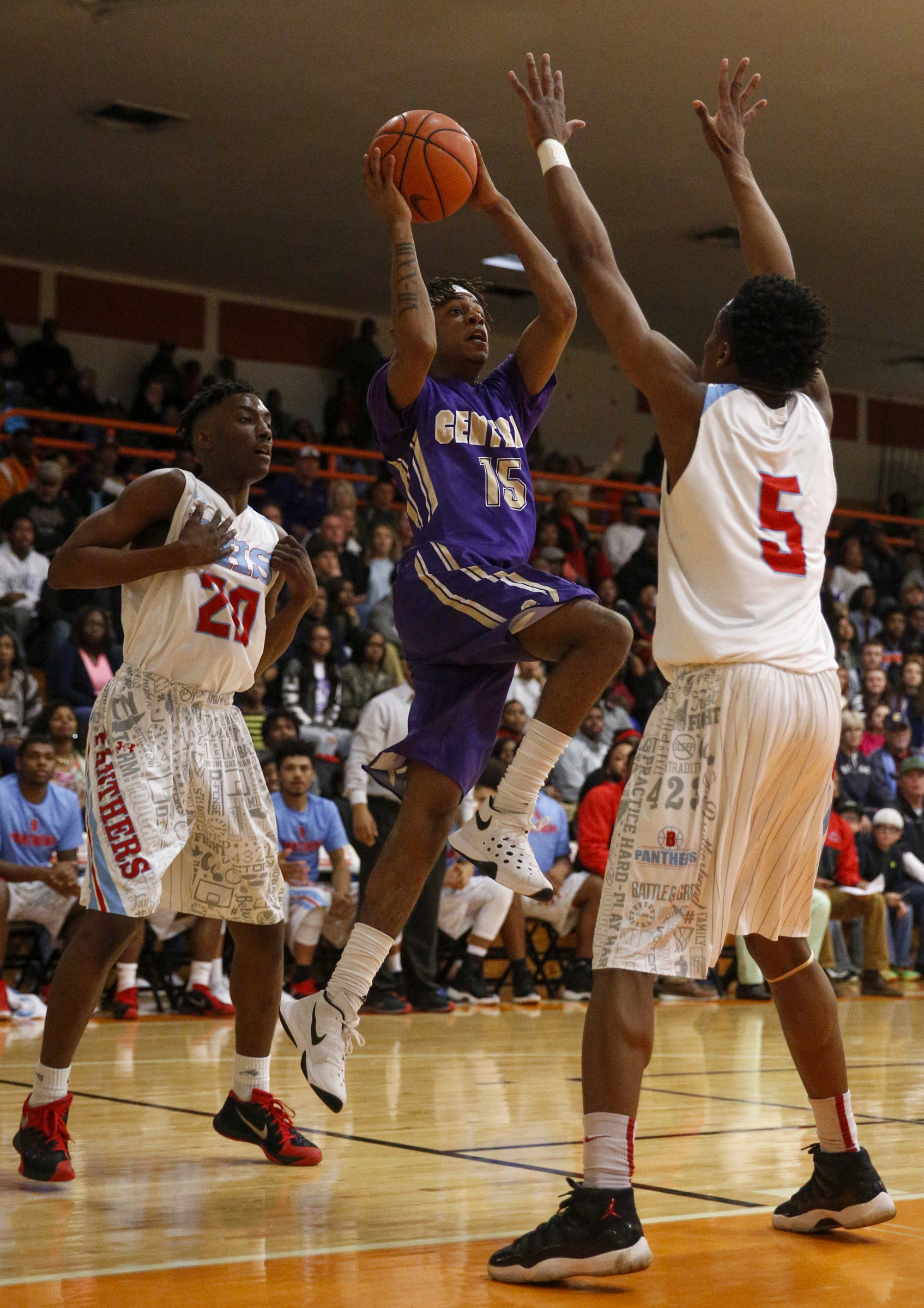 Central's Rodney Benford (15) shoots between Brainerd's Malik Beavers (20) and Dajuonta Ross (5) during their Region 3-AA boys' basketball tournament championship game at East Ridge High School on Thursday, March 3, 2016, in East Ridge, Tenn.