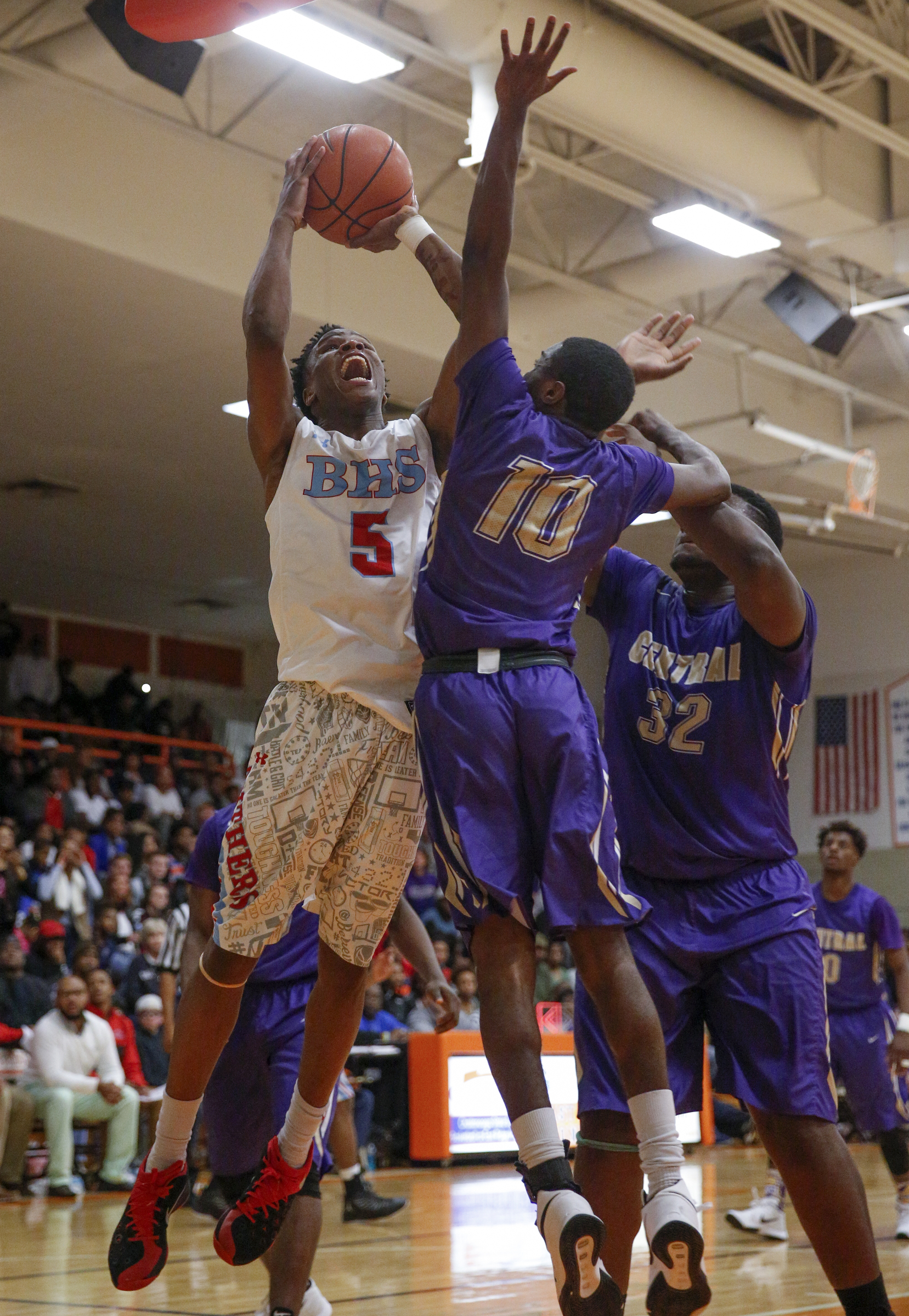 Brainerd's Dajuonta Ross (5) shoots into Central's Dajon Baxter (10) and McClendon Curtis (32) during their Region 3-AA boys' basketball tournament championship game at East Ridge High School on Thursday, March 3, 2016, in East Ridge, Tenn.