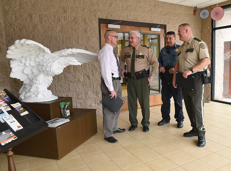 In the lobby of Monteagle City Hall, Tennessee Highway Patrol Col. Tracy Trott, second from left, talks with the top men of Grundy County police departments Friday following an awards presentation for a fatality-free year on Grundy roadways. From left are Monteagle Police Chief Virgil McNeece, Trott, Tracy City Police Chief Charlie Wilder and Grundy County Sheriff Clint Shrum.