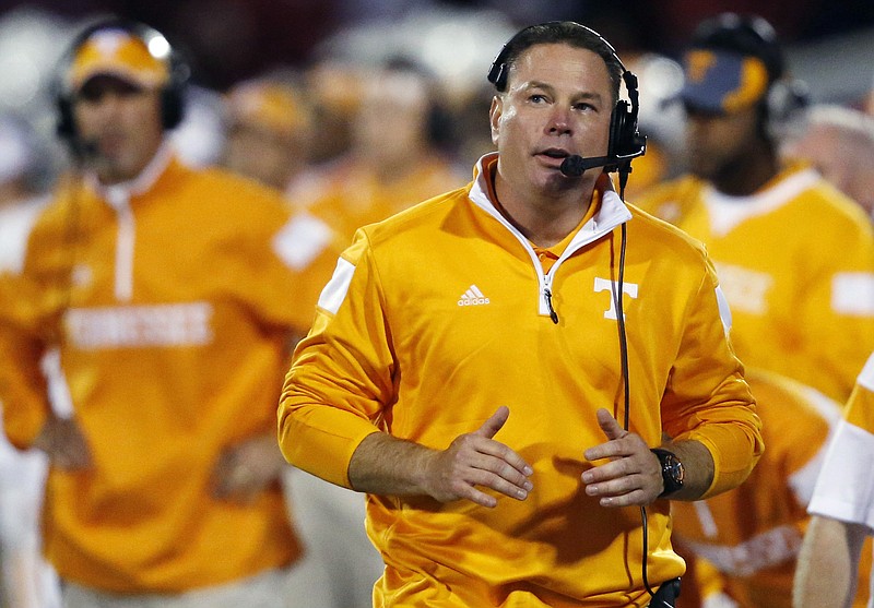 In this Saturday, Sept. 13, 2014 file photo, Tennessee coach Butch Jones talks into his microphone as he walks along the sideline in the third quarter of an NCAA college football game against Oklahoma in Norman, Okla. Tennessee football coach Butch Jones briefly referred to the Title IX lawsuit facing the university while speaking at a coaching clinic, Friday, March 4, 2016.(AP Photo/Sue Ogrocki, File)