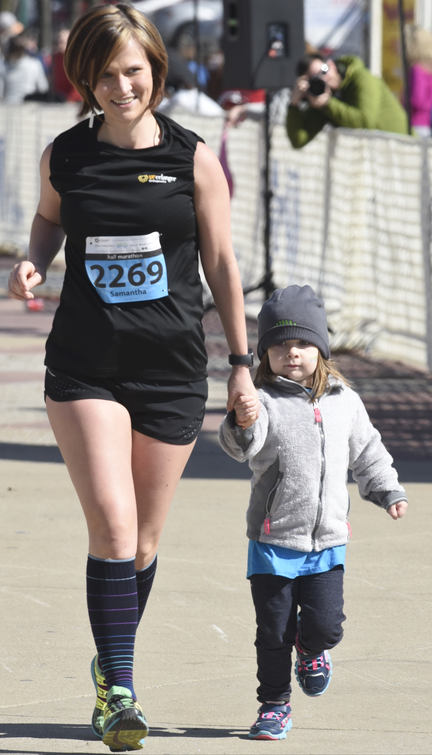Emily Dmochowski holds the hand of her mother Samantha Dmochowski as she crosses the finish line at the Chattanooga Marathon on Sunday, Mar. 6, 2016, in Chattanooga, Tenn.
