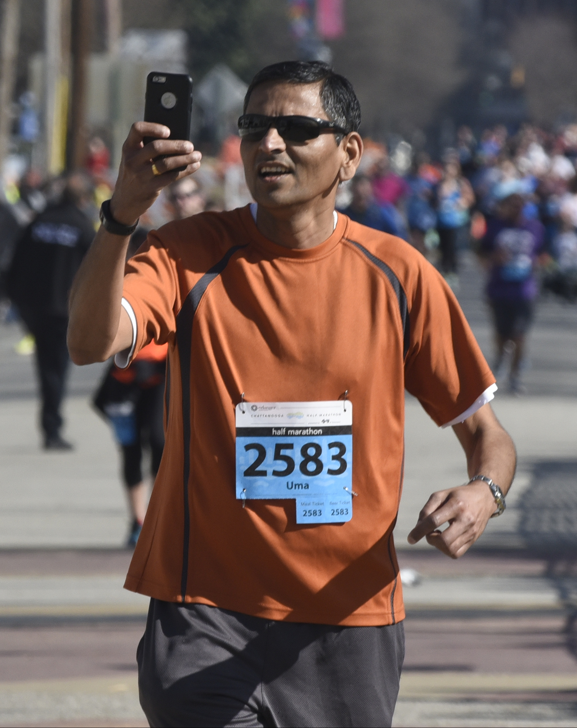 Uma Krishnamoorthy takes a photograph of himself as he crosses the finish line during the first running of the Chattanooga Marathon on Sunday, Mar. 6, 2016, in Chattanooga, Tenn.