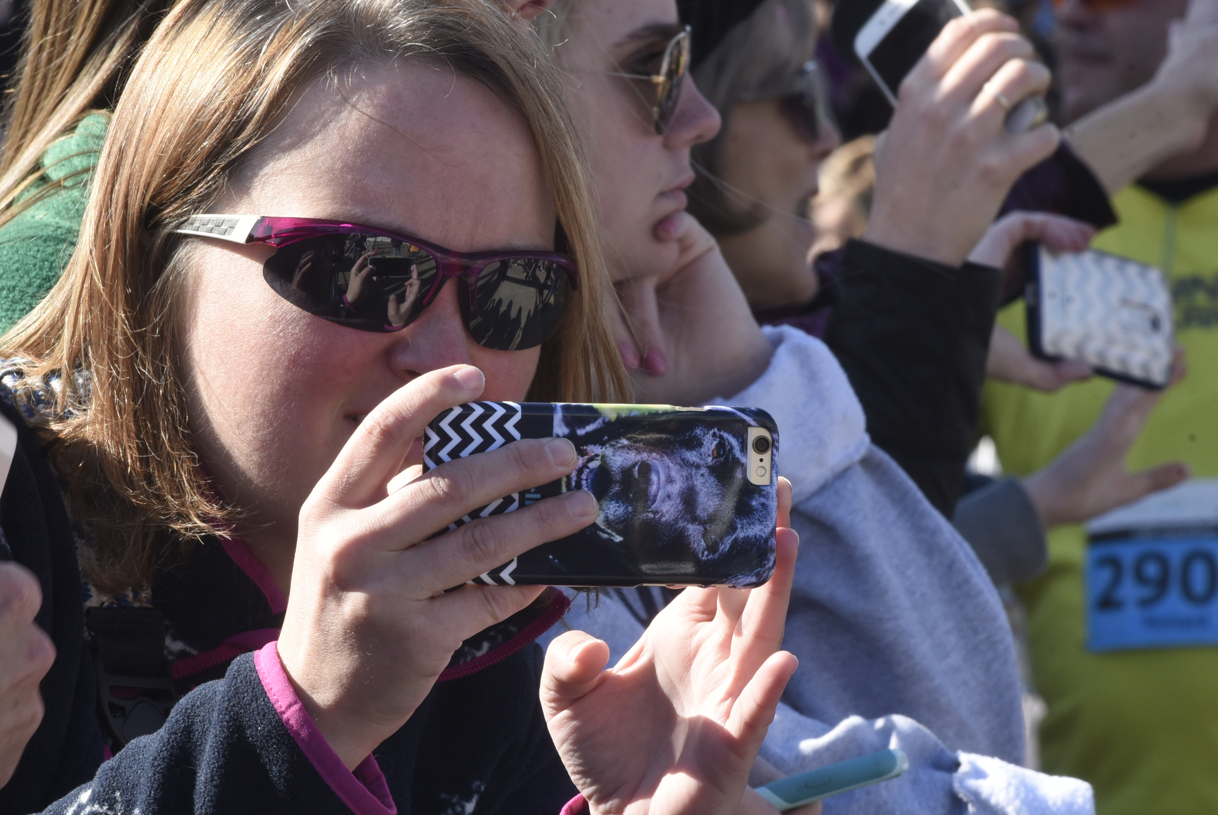 Rachel Lockhart uses her phone to take photographs as she waits for her sister April Grubbs to cross the finish line during the first running of the Chattanooga Marathon on Sunday, Mar. 6, 2016, in Chattanooga, Tenn.
