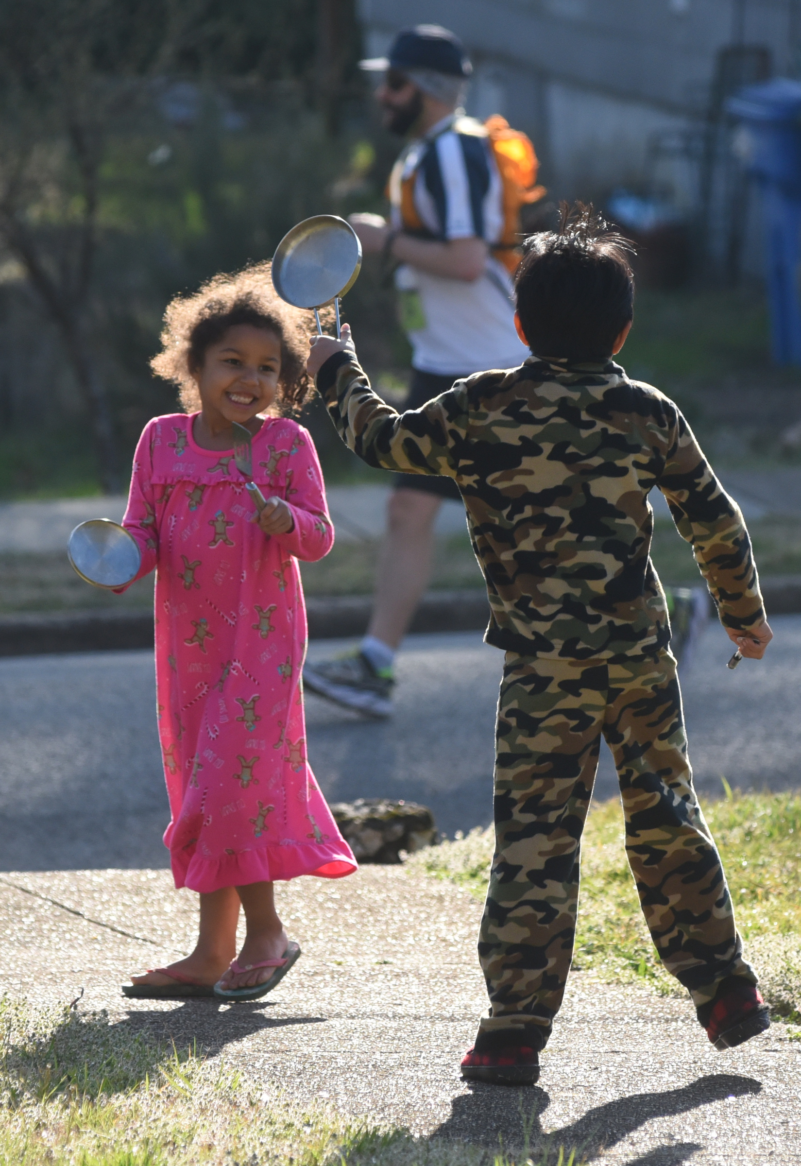 Isabel and Isaac Singer-Seymour beat on pan lids to encourage runners as they pass by their St. Elmo home during the first running of the Chattanooga Marathon on Sunday, Mar. 6, 2016, in Chattanooga, Tenn.