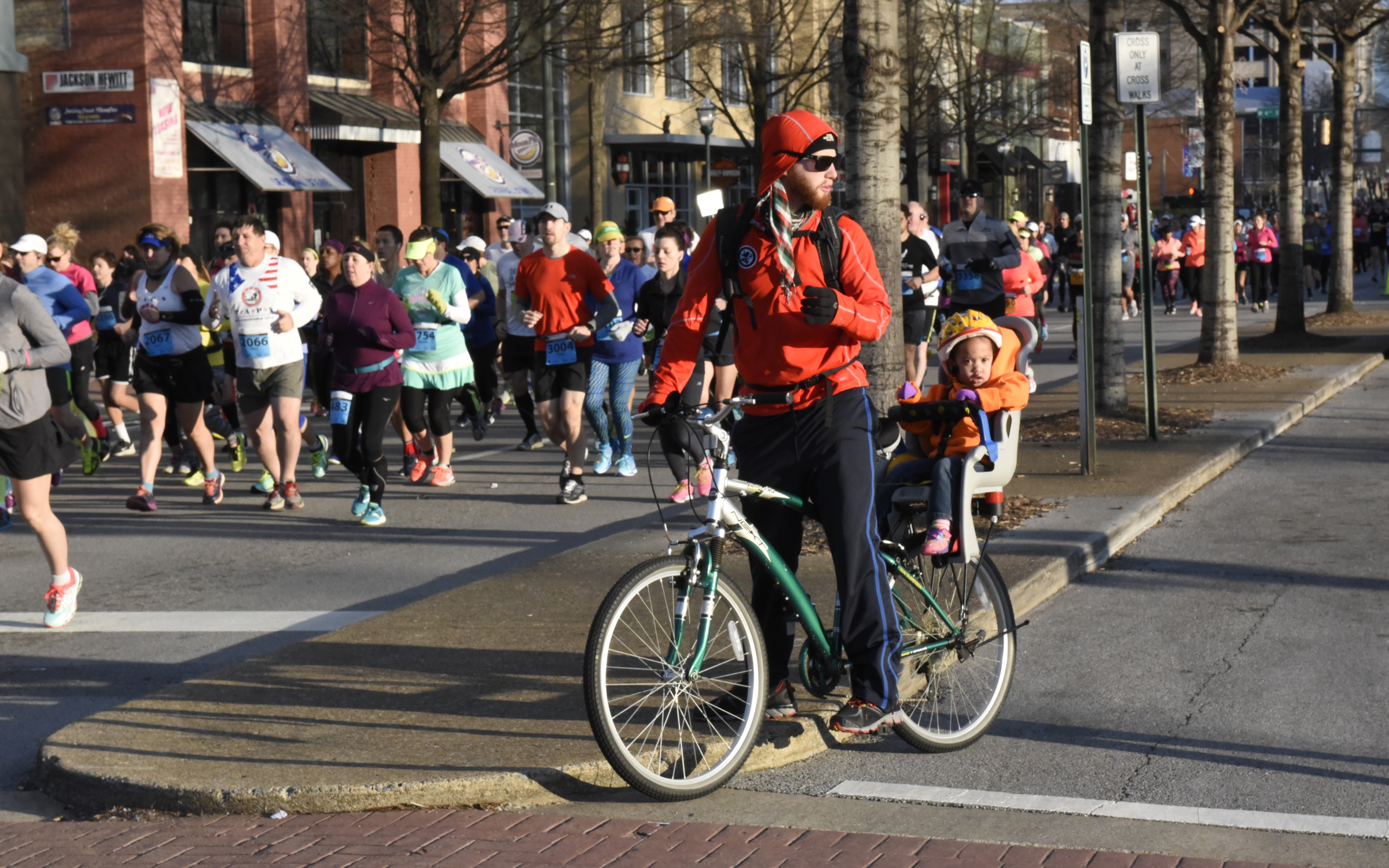 Ben Marshall and his daughter Salome Marshall watch from a bicycle near the starting line of the first running of the Chattanooga Marathon on Sunday, Mar. 6, 2016, in Chattanooga, Tenn.
