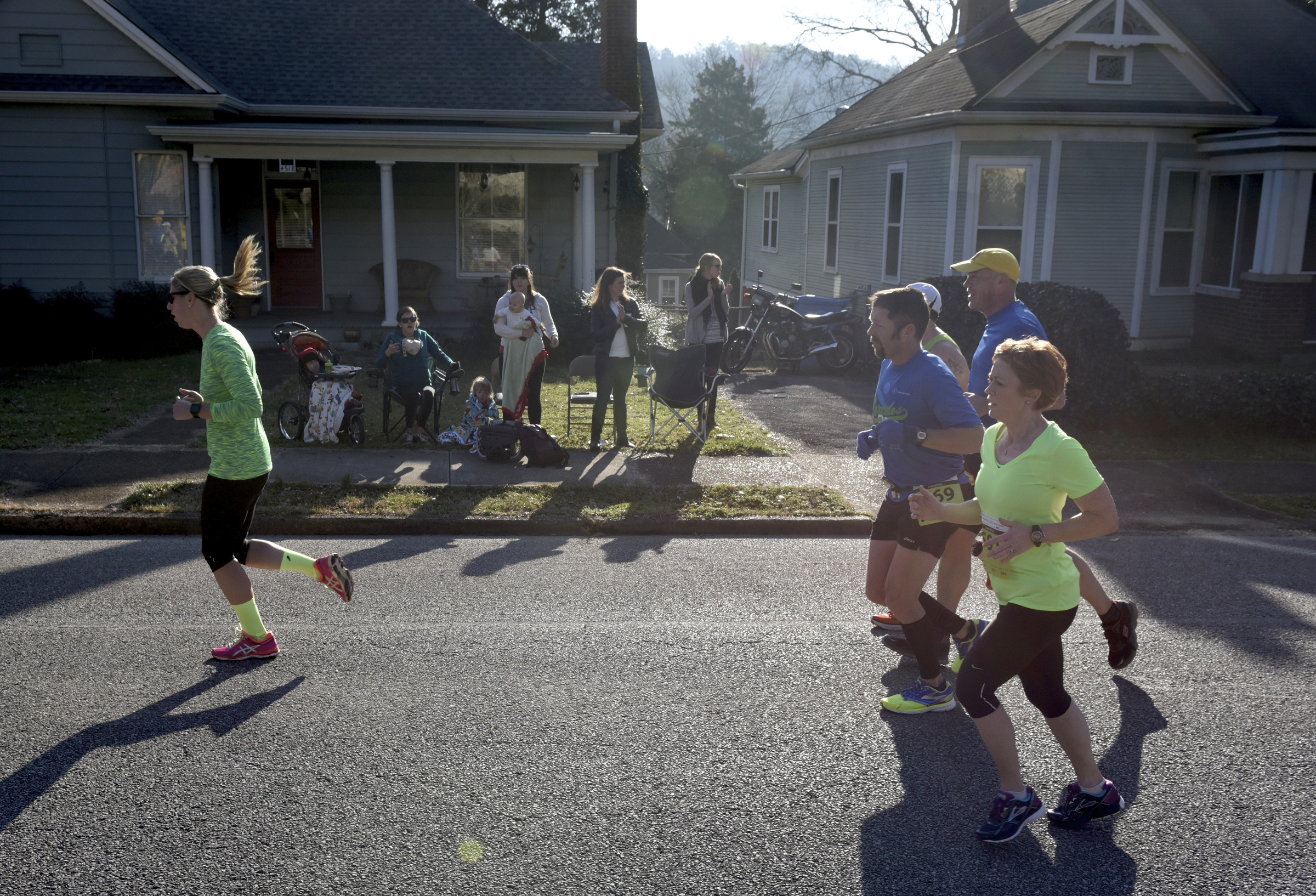 St. Elmo residents watch from their front yard and encourage runners passing by during the first running of the Chattanooga Marathon on Sunday, Mar. 6, 2016, in Chattanooga, Tenn.