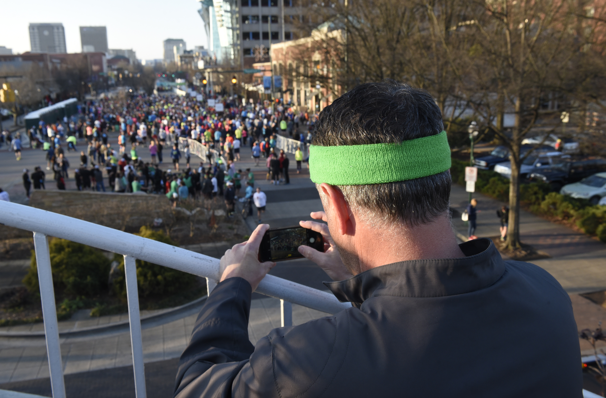Skip Fox, from Knoxville, takes a photograph from the Tennessee Aquarium Plaza prior to the start of the first running of the Chattanooga Marathon on Sunday, Mar. 6, 2016, in Chattanooga, Tenn.