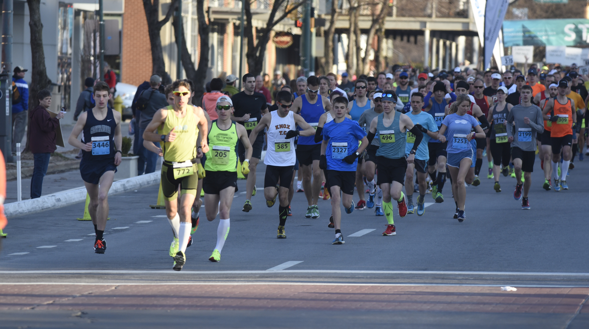 Runners leave the starting line during the first running of the Chattanooga Marathon on Sunday, Mar. 6, 2016, in Chattanooga, Tenn. Bob Adams, seen in the center wearing a white shirt and checking his watch, was the winner of the full marathon.
