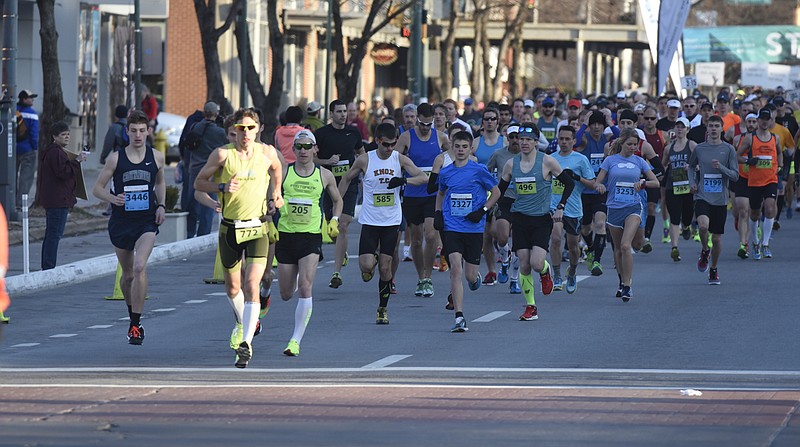 Runners leave the starting line during the first running of the Chattanooga Marathon on Sunday, Mar. 6, 2016, in Chattanooga, Tenn. Bob Adams, seen in the center wearing a white shirt and checking his watch, was the winner of the full marathon. 