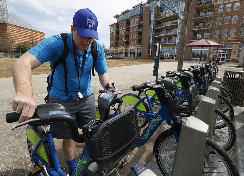 Staff Photo by Dan Henry / The Chattanooga Times Free Press- 3/7/16. Kelsey and Landon Welch check rent bikes from the Chattanooga Bicycle Transit System kiosk near the Aquarium on Monday, March 7, 2016. 