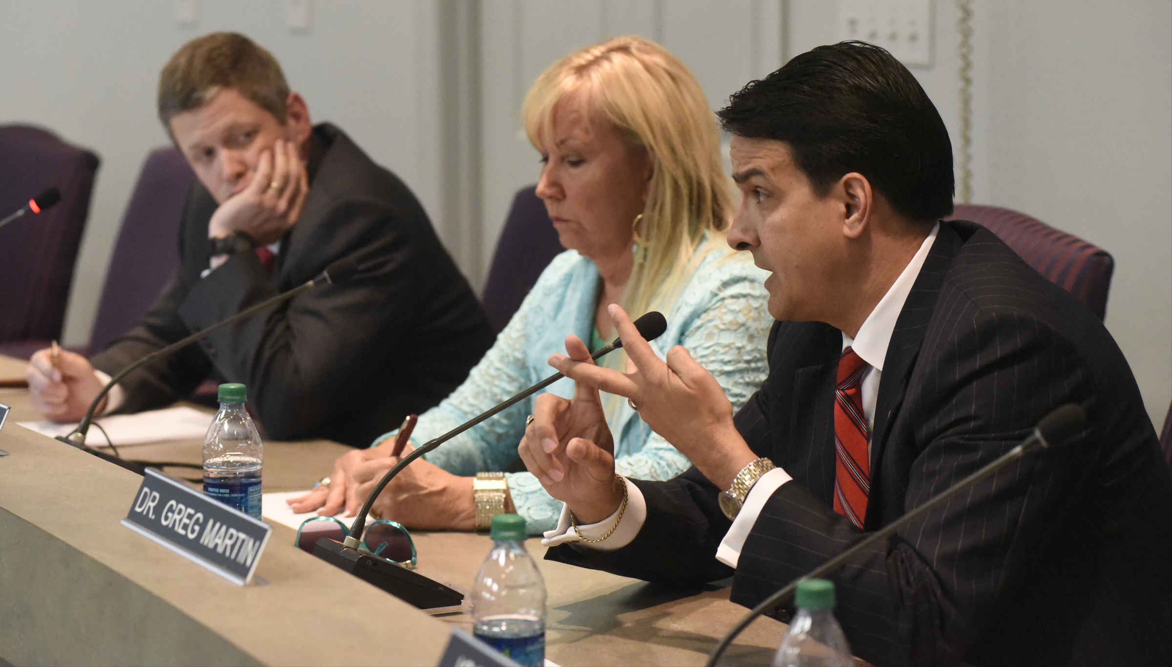 Dr. Greg Martin, right, speaks during the meeting of the Hamilton County School Board on Monday, Mar. 7, 2016, in Chattanooga, Tenn., while Dr. Jonathan Welch and Donna Horn, from left, listen. The board declined to take action, leaving Rick Smith in place as superintendent.