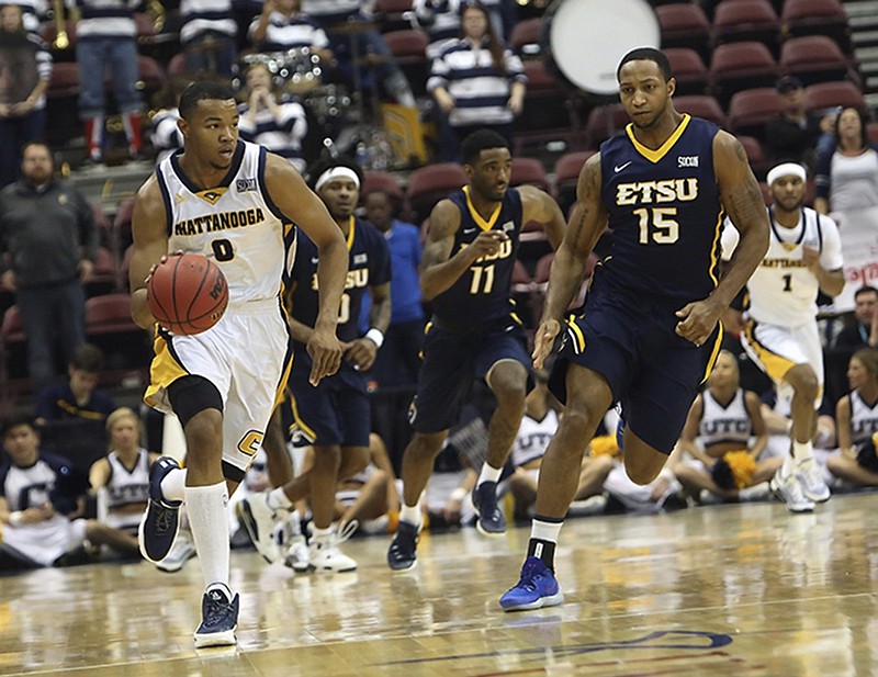 UTC's Chuck Ester dribbles up the court as ETSU's Lester Wilson trails the play during Monday's Southern Conference championship game in Asheville, N.C. Ester finished with eight points and five rebounds as the Mocs beat the Bucs 73-67.