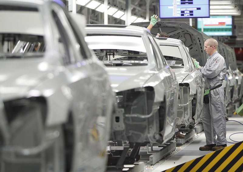 Staff photo by Dan Henry/Steven Rodriguez, right, examines sealed Passat bodies while at the VW paint shop at the company's Chattanooga plant in this file photo.