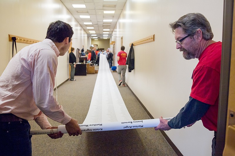 Protesters unfurl a banner at the legislative office complex in Nashville, Tenn., on Tuesday, March 8, 2016, that lists names of people who signed a petition opposing Republican Gov. Bill Haslam's plan to outsource maintenance work at more state buildings, including on college campuses. The demonstrators unfurled banners, chanted and sang in the hallways outside the Senate committee room where the Haslam was administration was scheduled to present its "business justification" for privatization efforts later on Tuesday. (AP Photo/Erik Schelzig)