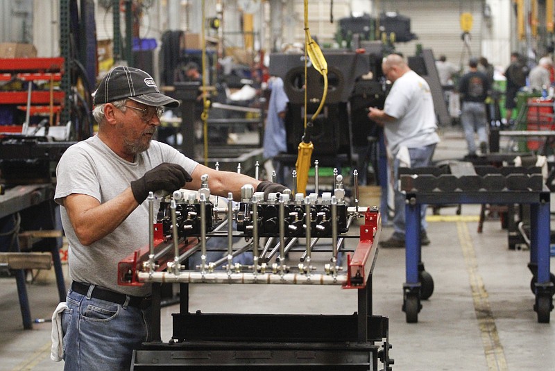 Randy Cook assembles a hydraulic valve set while in the large wrecker assembly shop at the Ooltewah, Tenn., branch of Miller Industries Inc. in 2013. 