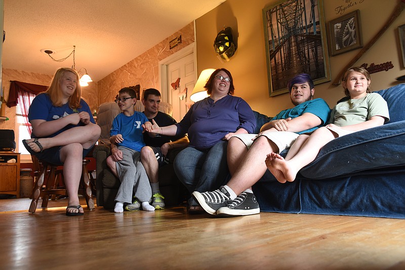 Joey and Fran Quarles, center, adopted a brother and sister last week. The Quarles have three other children who have been with them for the past three years. Seated from left are the two newest arrivals, Abby, 16, and Kalob, 9. Tott Hawkins, 16, and Lacy, 12, are seen, right.