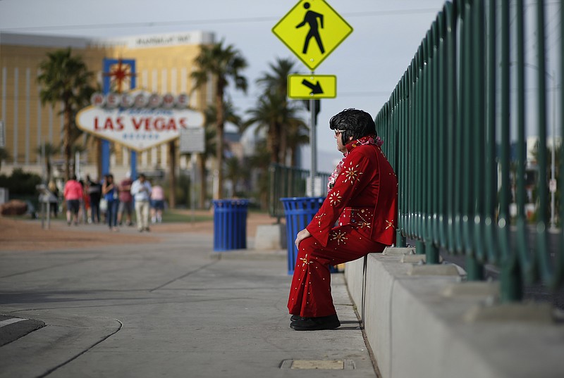 
              In this March 3, 2016, photo, Ted Payne rests as he works for tips dressed as Elvis at the "Welcome to Las Vegas" sign in Las Vegas. For decades, Las Vegas has loved Elvis Presley. But the King's presence in modern day Sin City has lately been diminishing. (AP Photo/John Locher)
            