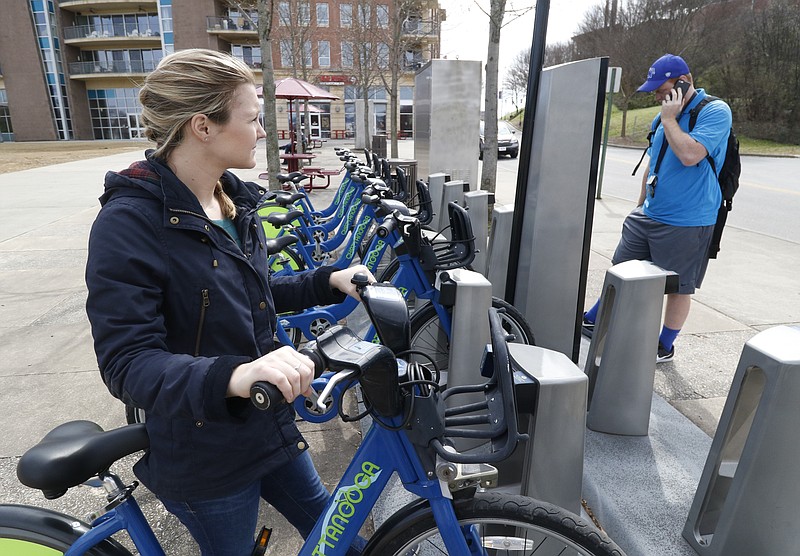 Kelsey and Landon Welch check rental bikes from the Chattanooga Bicycle Transit System kiosk near the Tennessee Aquarium on March 7.