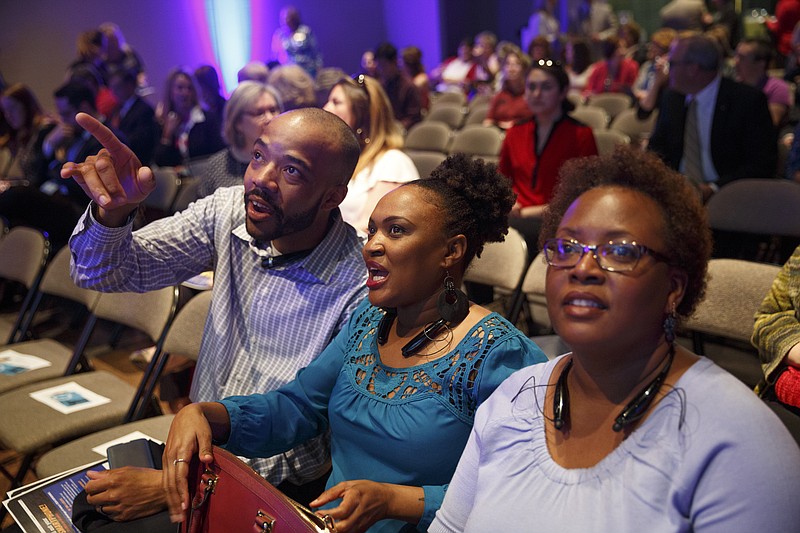 Brandon Bacon, Shelah Griggs, and Carol Johnson look up at a scrolling screen of tweets about United Way at the annual United Way of Greater Chattanooga Community Celebration on Tuesday, March 15, 2016, in Chattanooga, Tenn. Dr. Elaine Swafford, executive director of Chattanooga Girls' Leadership Academy, was the keynote speaker.