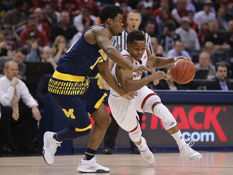 Indiana's Yogi Ferrell (11) drives against Michigan's Derrick Walton Jr. (10) in the first half of an NCAA college basketball game in the quarterfinals at the Big Ten Conference tournament, Friday, March 11, 2016, in Indianapolis. (AP Photo/Kiichiro Sato)