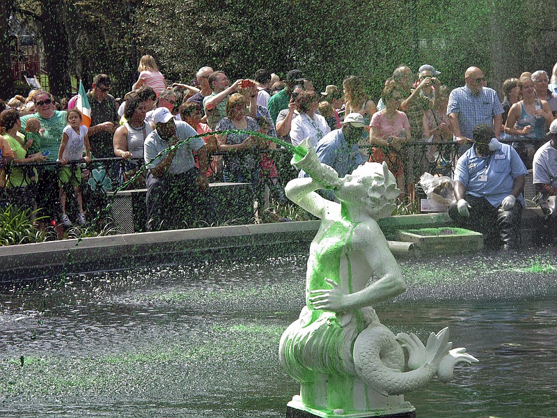 
              In this Friday, March 11, 2016 photo, a crowd watches as the cast-iron fountain in Forsyth Park sprays water dyed green less a week before the St. Patrick's Day parade in Savannah, Ga. While dying the fountains in Savannah's parks is a longstanding St. Patrick's Day tradition, many visitors believe the city dyes the Savannah River as well. That happened only once in 1961. (AP Photo/Russ Bynum)
            