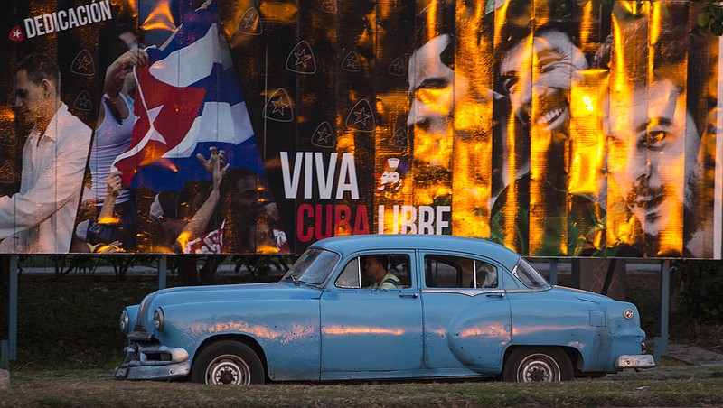 A taxi driving a classic American car passes a billboard that reads in Spanish: "Long live free Cuba" in Havana, Cuba, Monday, March 14, 2016.