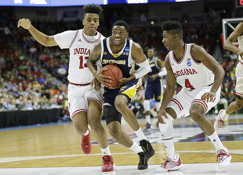 Chattanooga forward Tre' McLean, center, drives to the basket between Indiana's Juwan Morgan, left, and Robert Johnson, right, during the first half of a first-round men's college basketball game in the NCAA Tournament, Thursday, March 17, 2016, in Des Moines, Iowa. (AP Photo/Charlie Neibergall)