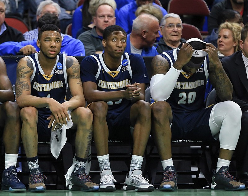 Chattanooga's Johnathan Burroughs-Cook (4), Eric Robertson (15) and Duke Ethridge (20) sit on the bench during the final minutes of a first-round men's college basketball game against Indiana in the NCAA Tournament in Des Moines, Iowa, Thursday, March 17, 2016.  (AP Photo/Nati Harnik)