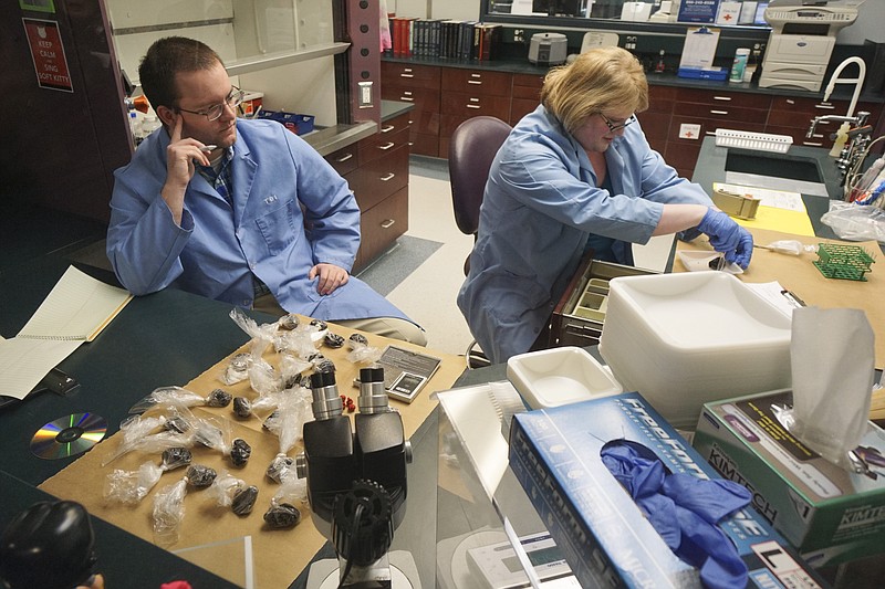 Staff Photo by Dan Henry / The Chattanooga Times Free Press- 3/27/15. TBI intern Cameron Massey, left, watches as Ella Carpenter works with Heroin at the Tennessee Bureau of Investigation's forensic chemistry lab on Friday, March 27, 2015. 