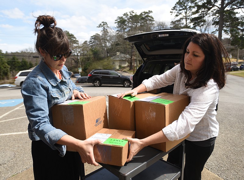 Rachel Carroll, left, and Kristen Adams load boxes of test materials to take into Normal Park Upper School Thursday, March 10, 2016.