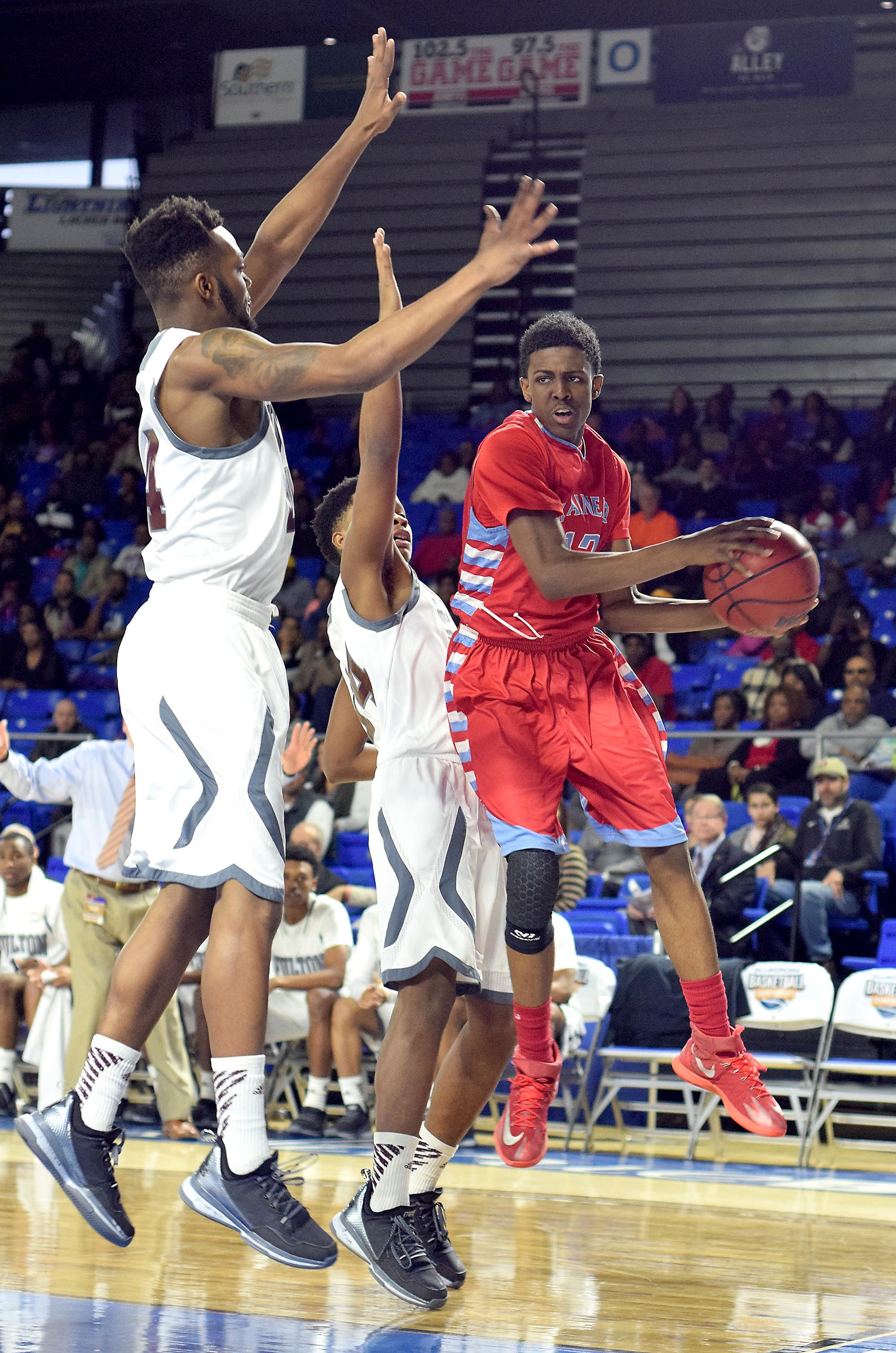 Brainerd's Vesta Melvin (12) looks to pass as he drives the baseline while two Falcons defend. The Brainerd High Panthers faced the Fulton High Falcons in the TSSAA State Division I Class AA Championship at the Murphy Center on the campus of Middle Tennessee State University in Murfreesboro March 19, 2016.