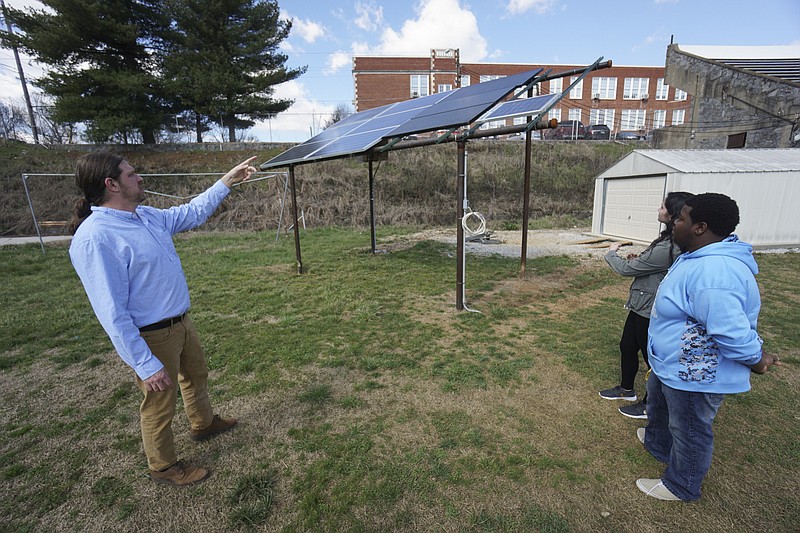 Staff Photo by Dan Henry / The Chattanooga Times Free Press- 2/29/16. David Mounger, the Energy Systems teacher at Chattanooga School for the Arts and Sciences, speaks with senior class students J'darius Cameron and Kalin Ledford about a solar panel project that they and other students completed which is located on the school's football field and has the ability to add energy to the grid. 