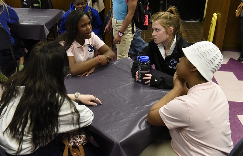 Brainerd students Ashenia Tatum, second from left, and Kizzy Carmichael, right, talk with Carly Perry. left, and Mary Grace Coffman as students from a social justice class at the Girls Preparatory School visit Brainerd High School on Thursday, Mar. 24, 2016, in Chattanooga, Tenn.