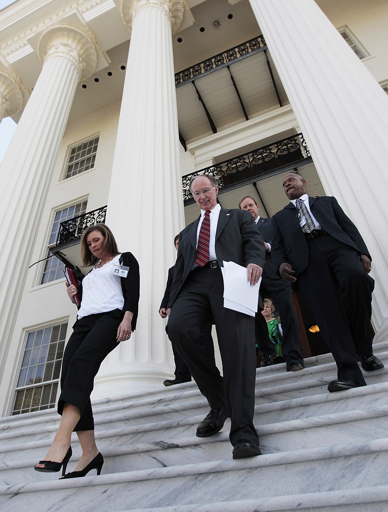 In this Tuesday, March 22, 2011 file photo Alabama Gov. Robert Bentley, center, arrives for a news conference at the Alabama Capitol in Montgomery, Ala. At left is Rebekkah Mason, Bentley's Communications Director. Bentley admitted Wednesday, March 23, 2016, that he made inappropriate remarks to his senior political adviser, Rebekah Caldwell Mason. Bentley said he did not have a sexual relationship with Mason, but he apologized to his family and Mason's for his behavior. (AP Photo/Dave Martin, File)