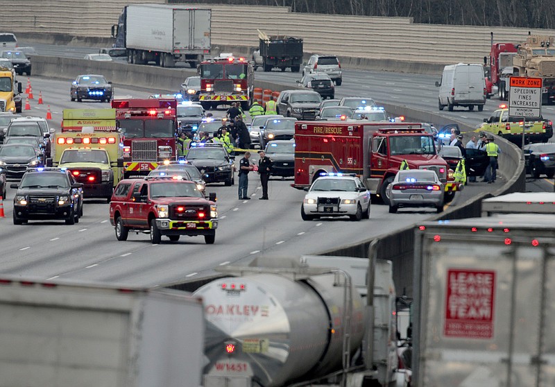 Police work at the scene of an officer-involved shooting on I-75 in Cobb County on Wednesday, Jan. 27, 2016. Georgia State Police say they were trying to stop a speeder following a 10-mile chase when the speeder struck another vehicle and exited his truck with a gun. A state trooper and a suspect were shot Wednesday, in a police chase in suburban Atlanta, the Georgia State Patrol said. The GSP said in an email that the trooper and suspect were shot in a pursuit on Interstate 75 in Marietta. (Ben Gray/Atlanta Journal-Constitution via AP)