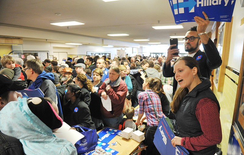 Hillary Clinton volunteers Amy Paxson, far right, and Charles Tice work the crown for their candidate at the Democratic party caucus in Anchorage, Alaska Saturday, March 26, 2016. Alaska Democrats planned to meet to pick their candidate for president, with caucus sites set up around the state. (AP Photo/Michael Dinneen)