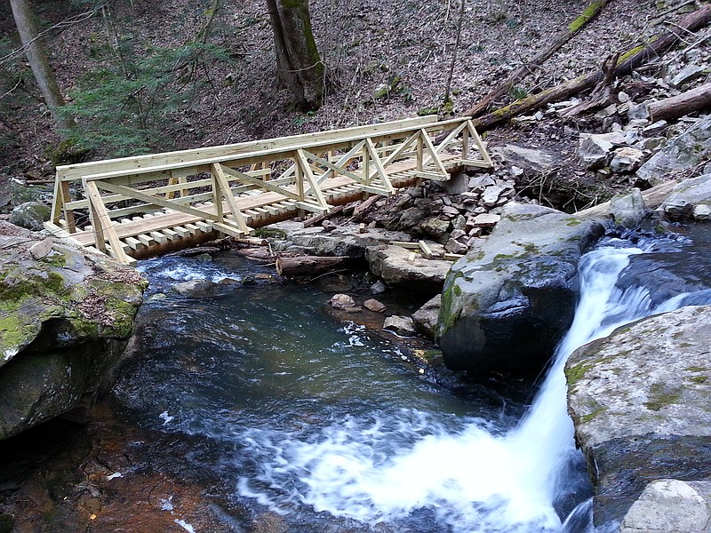 This 28-foot-long bridge spanning McAlloyd Branch is ready for South Cumberland State Park hikers months ahead of schedule, completing what officials say is one of the most difficult pieces of the Fiery Gizzard Trail reroute. The rerouting work stems from a request from a private landowner to remove the trail from his land. A recent similar request from a second landowner means an additional mile of trail must be added to the rerouting project. Volunteers have logged more than 3,000 hours to move the timeline for completion up.