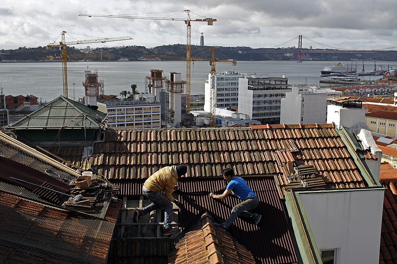
              FILE - In this Feb. 28, 2014 file photo, construction workers repair the roof of a building in Lisbon. The country’s construction sector collapsed amid the financial crisis, which saw the state take a 78 billion-euro ($87 billion) bailout in 2011. The number of construction workers has more than halved from 612,000 in 2005 to roughly 277,000. (AP Photo/Francisco Seco)
            