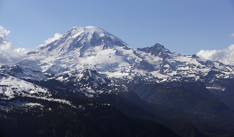 
              FILE -- In this file photo taken June 19, 2013, Mount Rainier is seen from a helicopter flying south of the mountain and west of Yakima, Wash. One climber has likely died from hypothermia and exposure on Mount Rainier after he and his climbing partner were caught in a winter storm over the weekend, a spokeswoman with Mount Rainier National Park said. A Chinook helicopter crew and other rescue teams were working Monday, March 28, 2016, to reach the 58-year-old man from Norway. (AP Photo/Elaine Thompson, File)
            