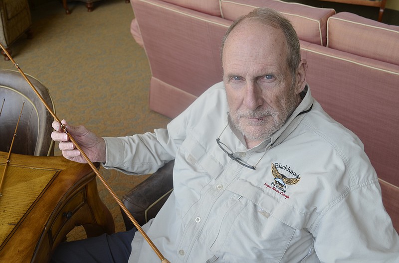 Dan Quarles sits in his Alexian Village apartment with one of his handcrafted bamboo fly rods. He's helped numerous people build fly rods since he began studying it, as well as donating several more to various charities in the area.