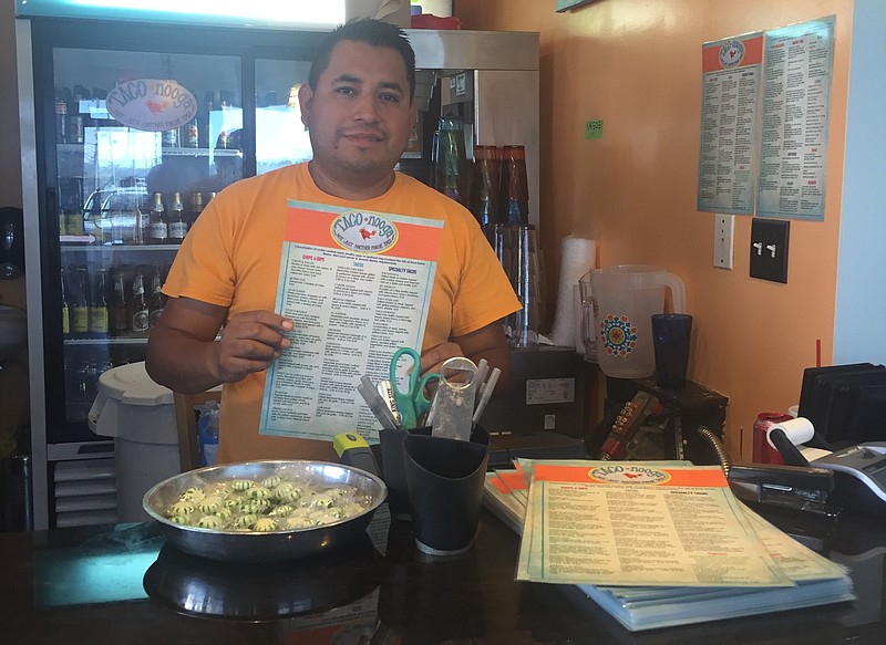 Taconooga owner Armando Castro stands behind the register of his business' new location on East Brainerd Road.