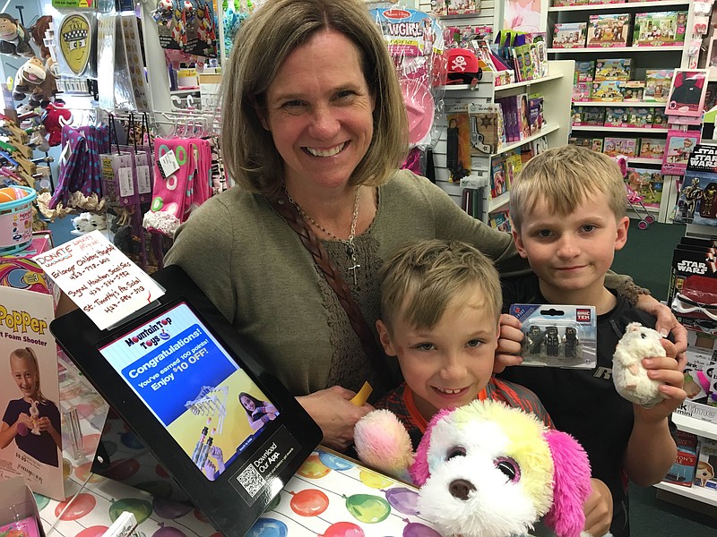 Mountain Top Toys recognizes its 2,000th customer to receive loyalty points from the store's rewards program. Tonya Campbbell is pictured with her two sons.