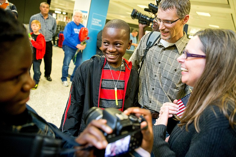 
              FILE - In this Nov. 11, 2015 file photo, Jennifer and Eric Sands of Illinois, right, accompanied by their adopted daughter Joy, 12, left, smile as their adopted son Issaac, 12, center arrives from Congo at Dulles International Airport, in Dulles, Va. The number of foreign children adopted by U.S. parents dropped by 12 percent last year to the lowest level since 1981, according to new State Department figures. Even with the decline, Ethiopia was No. 2 on the list, followed by South Korea, Ukraine, Uganda, Bulgaria, Latvia and Congo.   (AP Photo/Andrew Harnik, File)
            