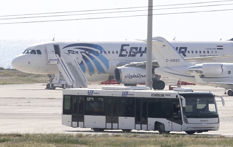 
              A bus carrying some passengers from a hijacked EgyptAir aircraft drives by the plane at Larnaca Airport in Cyprus Tuesday, March 29, 2016. The EgyptAir plane was hijacked on Tuesday while flying from the Egyptian Mediterranean coastal city of Alexandria to the capital, Cairo, and later landed in Cyprus where some of the women and children were allowed to get off the aircraft, according to Egyptian and Cypriot officials. (AP Photo/Petros Karadjias)
            