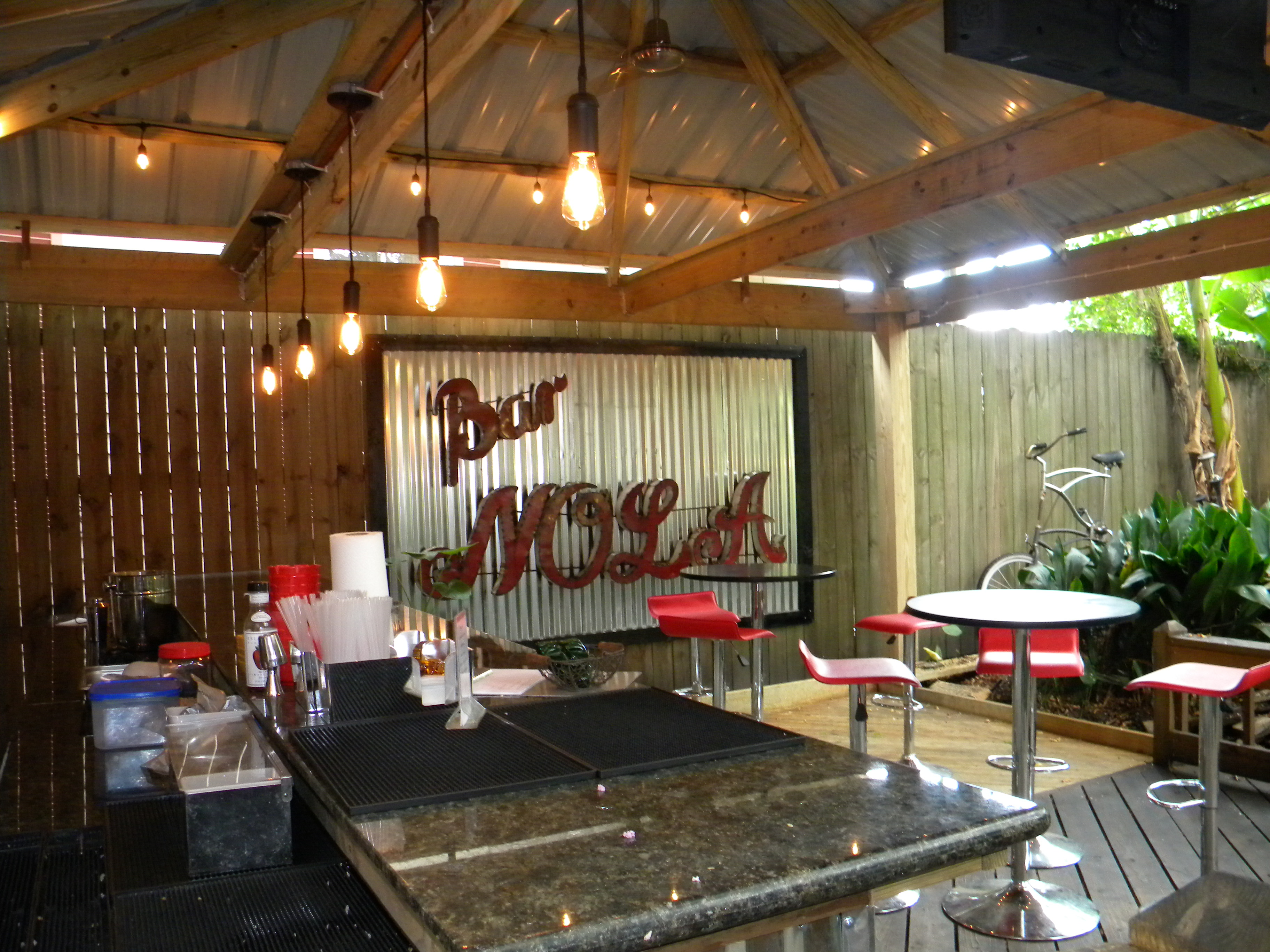 Enjoy a drink at the outdoor bar in the lush courtyard of the Maison de Macarty in New Orleans, Louisiana.