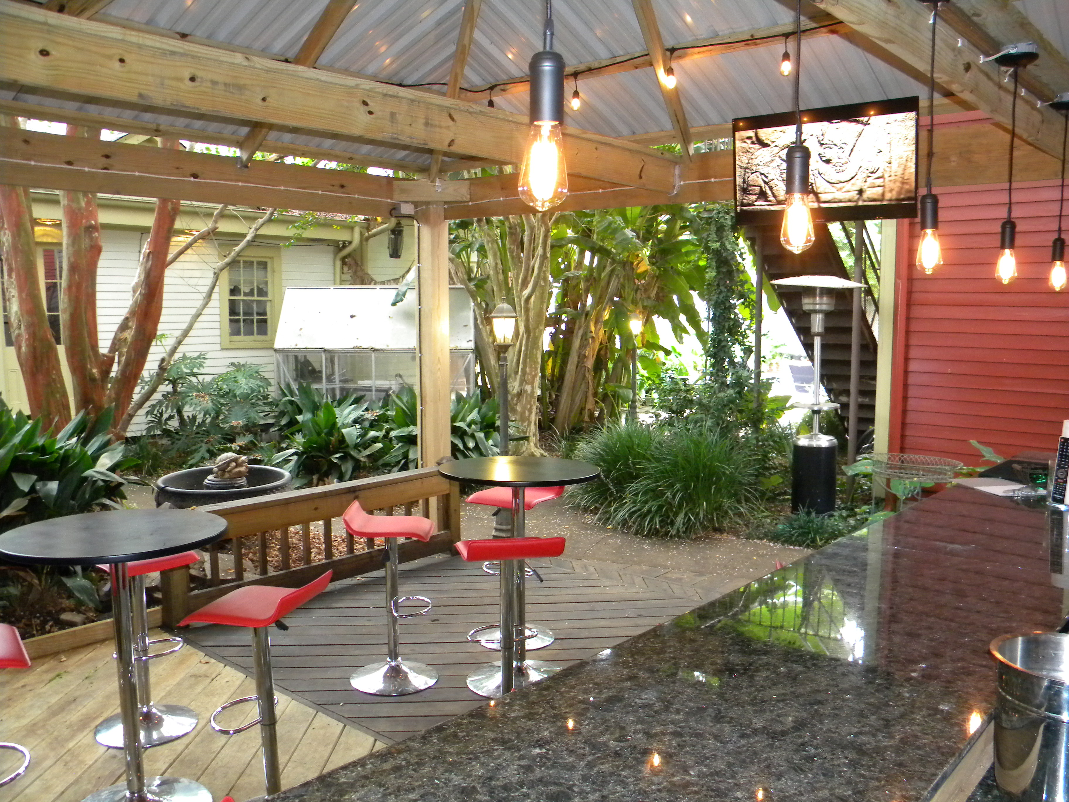 Enjoy a drink at the outdoor bar in the lush courtyard of the Maison de Macarty in New Orleans, Louisiana.