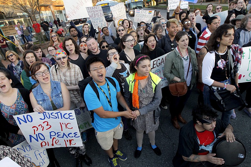 Protesters chant at the intersection of Franklin St. and Columbia St. where they formed a circled and stopped traffic for hours in Chapel Hill, N.C., Tuesday, March 29, 2016 to protest the recent passage of N.C. HB2. Republican Gov. Pat McCrory, seeking re-election in what's anticipated to be one of the nation's most heated and expensive campaigns, is doubling down on a sweeping law he signed last week preventing local governments from protecting people on the basis of sexual orientation and gender identity when they use public accommodations such as hotels and restaurants. People also would have to use multi-stall bathrooms that match their birth certificates at state agencies and public schools and universities.