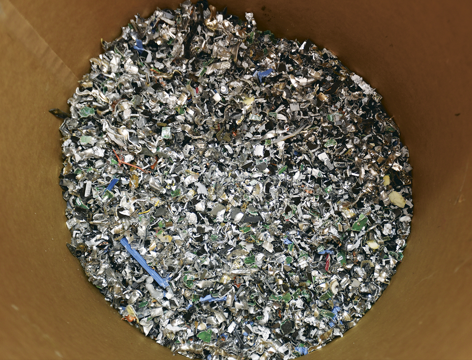 Bits of hard drives fill a bin Friday after they're shredded.